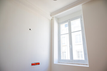 Fototapeta premium Mise en peinture de pièces lumineuses dans un appartement haussmannien de luxe, alliant élégance, raffinement et finitions haut de gamme.