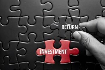 Fototapeta premium ROI Concept in Puzzle Form – Hand Placing Final Piece Connecting 