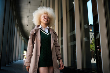 Stylish afro-american albino businesswoman walking in modern city