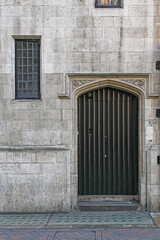 Closed Black Door and Window With Bars at Medieval Building in London