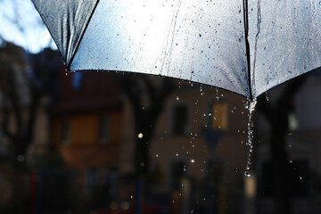 Open umbrella under pouring rain outdoors, closeup