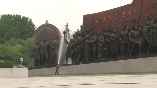 North Korean man cleaning the statues in Mansudae, Pyongyang, North Korea