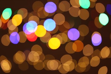 Blurred view of colorful lights on dark background, bokeh effect