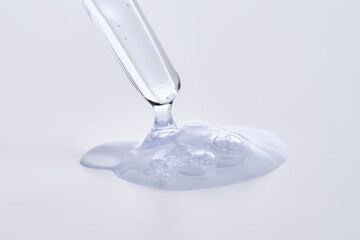 Pipette with delicate blue serum close-up.