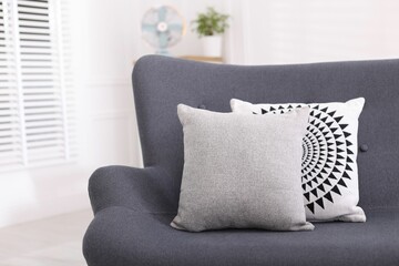 Soft decorative pillows on sofa in room. Space for text