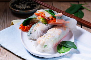 Summer or spring rolls with shrimp, vegetables and spinach, served with soy sauce and sesame. Traditional Vietnamese food.