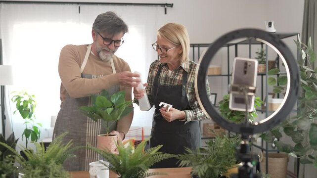 mature senior couple use mobile phone for live streaming care plants