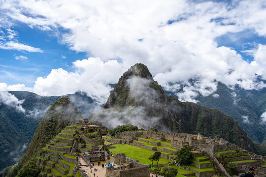Panoramic view of Machu Picchu ruins surrounded by misty mountains, Peru