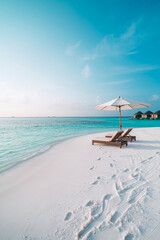 White beach with two sun loungers and an umbrella. Exotic vacation