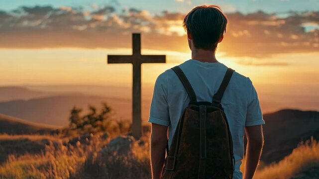 A young man with brown hair stands on the hill and looks at the sunset. In front of him is a cross, and he carries his leather bag over his shoulder. The sunset casts god rays