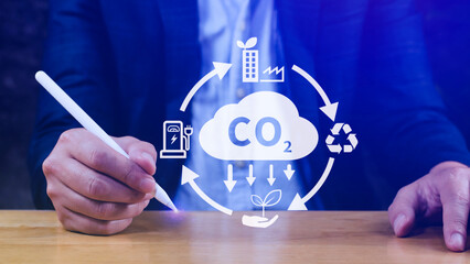 Hand holding CO2 reducing virtual icon for decrease carbon dioxide emission, carbon footprint and...