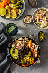 A hearty, balanced breakfast bowl with black quinoa, creamy avocado, roast chicken, sweet potatoes, zucchini, broccoli, and a fresh salad of cabbage and radish with chia and sesame seeds