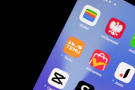 Warsaw, Poland - March 10, 2025: Close-up of smartphone screen showcasing various mobile applications, including Temu and AliExpress, against a dark background.