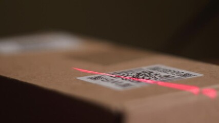 close up scanning QR code with laser beam of barcode scanner on parcel box close up , logistics center concept - Powered by Adobe