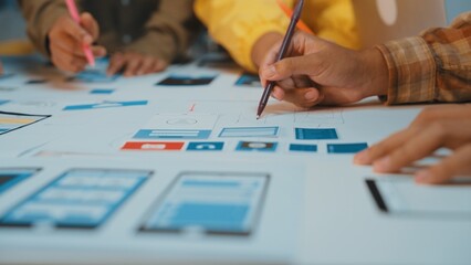 A dynamic team collaborates on user interface design using sketches and wireframes on a shared...