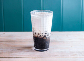 Grass Jelly Drink with Coconut Milk with ice cube served in glass isolated on wooden background side view of Hong Kong drink