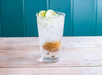 Salted Lemon and Lime Soda with ice cube served in glass isolated on wooden background side view of Hong Kong drink