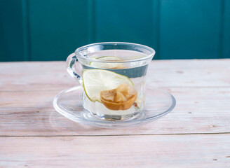 Hot Salted Lemon and Lime Water served in cup isolated on wooden background side view of Hong Kong hot drink