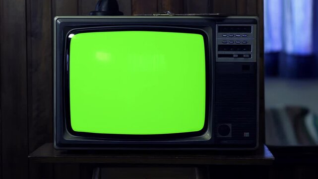 Remote Control Turning On and Off an Old TV With Green Screen in a Cozy Living Room - Evening, 100% real and not AI-generated - 4K
