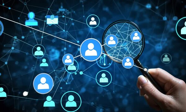 Hand holds magnifying glass over connected people icons in a network on a blue tech background