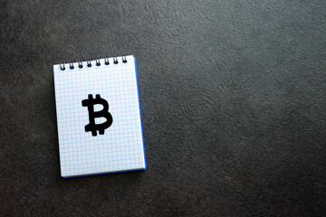Dollar, euro and bitcoin cryptocurrency symbols written on notepad