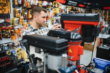 A man in a hardware store choosing a tool
