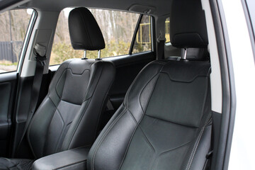 Leather car headrest seat details. Black leather car interior. Modern SUV interior. Car passenger...