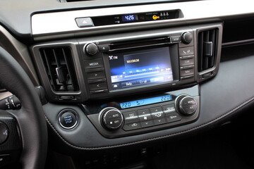 Screen multimedia system on dashboard in modern car. Panel of modern car. Close-up of an electronic dashboard in a modern car. Lux car dashboard with multimedia touch screen. SUV control panel.