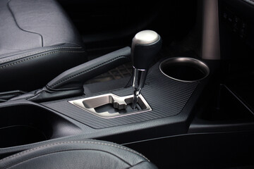Close up car automatic transmission. Gear shift in new electric car. Selector automatic transmission with leather in the interior of a new modern car. Car Black leather interior.