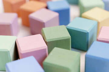 Colorful wooden toy blocks in pastel colors close up view