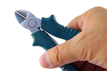The hand holds wire cutters with insulated handles. Transparent background in PNG.