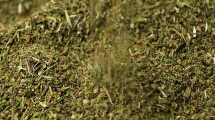 Culinary savory dried herb seasoning pour slow motion