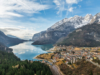 Aerial drone view of Lake Molveno, beautiful lake in Italy. Lake in dolomites from drone in winter. Lake Molveno in Italy. Sailboat, yacht on crystal clear lake in the Brenta Dolomites