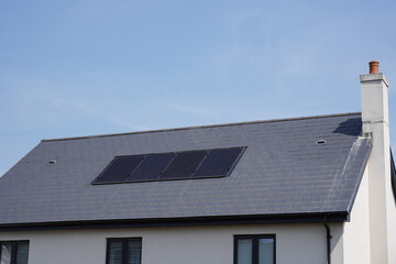 modern family home with solar panels on roof. residential house with solar photovoltaic cells installed 