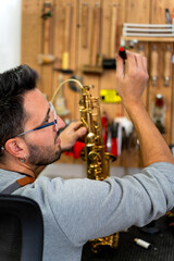 Luthier repairing saxophone in workshop