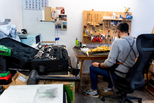 Luthier repairing wind instruments in his workshop