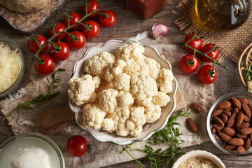 Fresh cauliflower,  almond meal, tomatoes, arugula and mozzarella - ingredients for homemade gluten-free pizza -