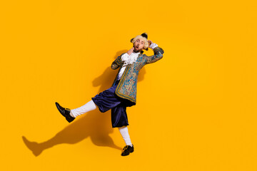 Portrait of a man in vintage noble costume against vibrant yellow background showcasing style and humor