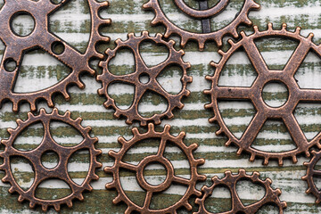Engranajes metálicos de cobre y bronce sobre una superficie rugosa