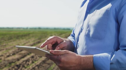 Businessman digital agricultural farmer with tablet. Hands holds gadget tablet. Regulation of agricultural production issues study of new technologies methods of soil plant care doing business online.