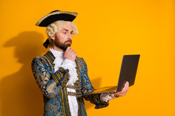 Man Dressed in Retro Costume Holding Laptop in Front of Yellow Background