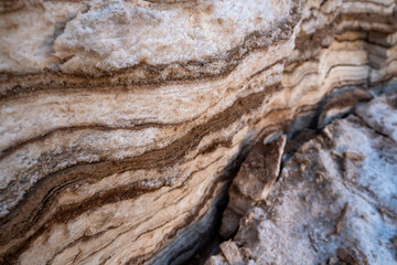 Layers of salt and rock on shore of Dead sea in Jordan, closeup detail