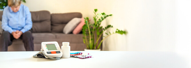 An old woman measures her blood pressure. Selective focus.