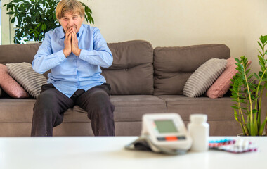An old woman measures her blood pressure. Selective focus.