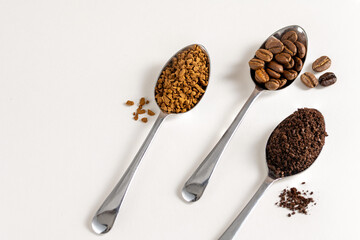 Roasted Coffee beans and different types of grinds coffee in spoons on white background.