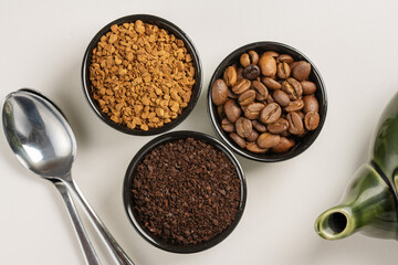 Different types of coffee. Ground coffee, instant coffee and roasted coffee beans in small bowls