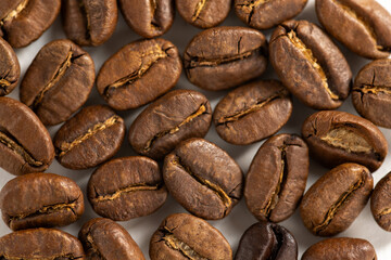 Roasted coffee beans over bright background