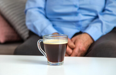 Old woman drinking coffee. Selective focus.