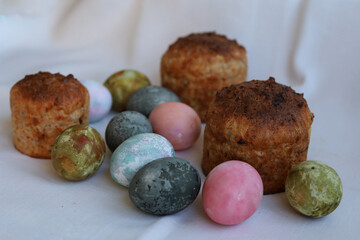 Easter cakes and colorful eggs on a white tablecloth