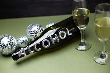 Glasses with champagne and a bottle with the inscription "Alcohol"